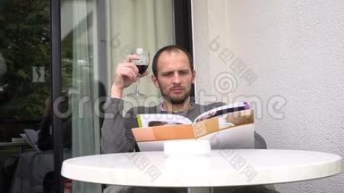 英俊的男人手里拿着杂志喝着一杯<strong>好酒</strong>。